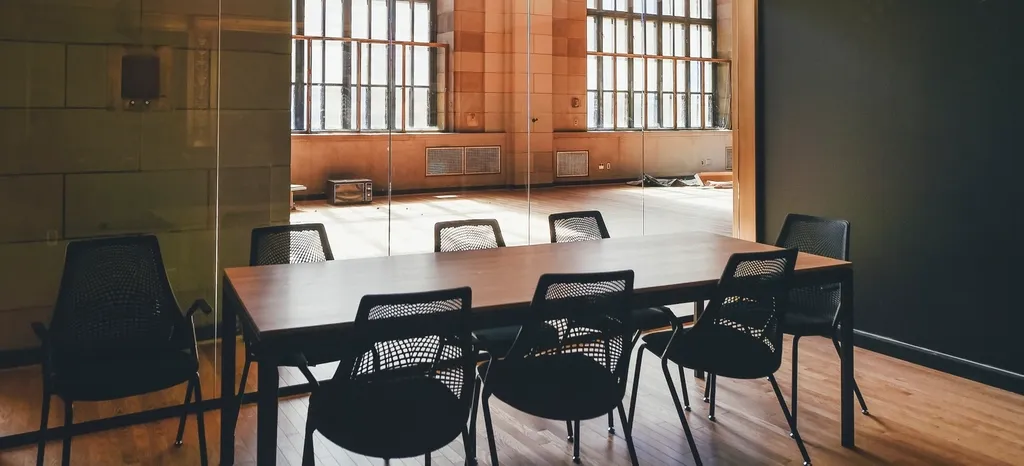 An empty meeting room with a long table and chairs